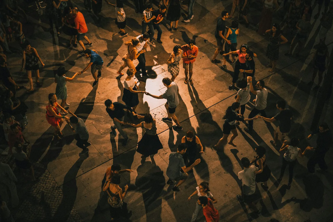 A dance floor full of people dancing a partnered dance.